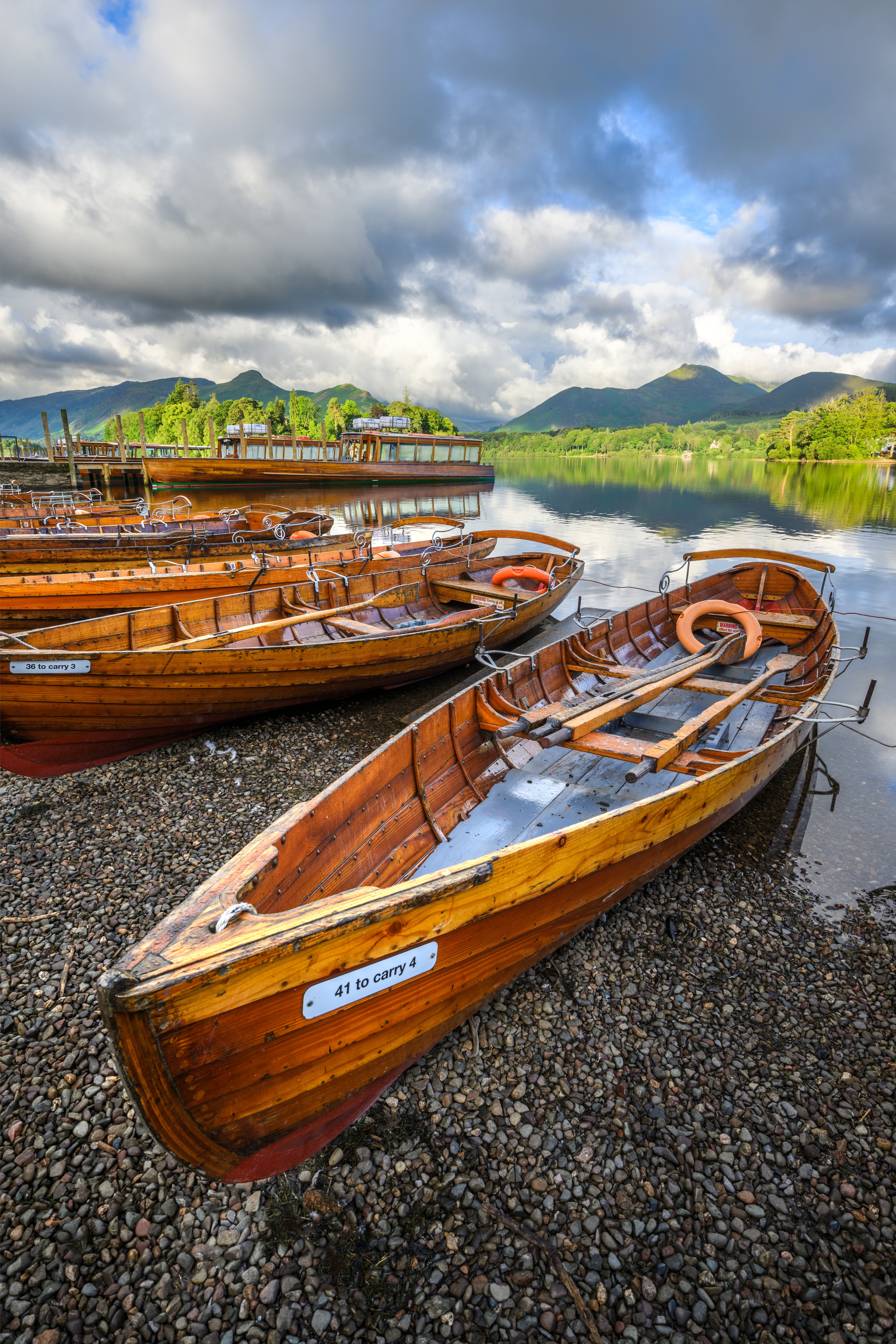 wooden rowing boats on shoreline of derwentwater in the lake district uk