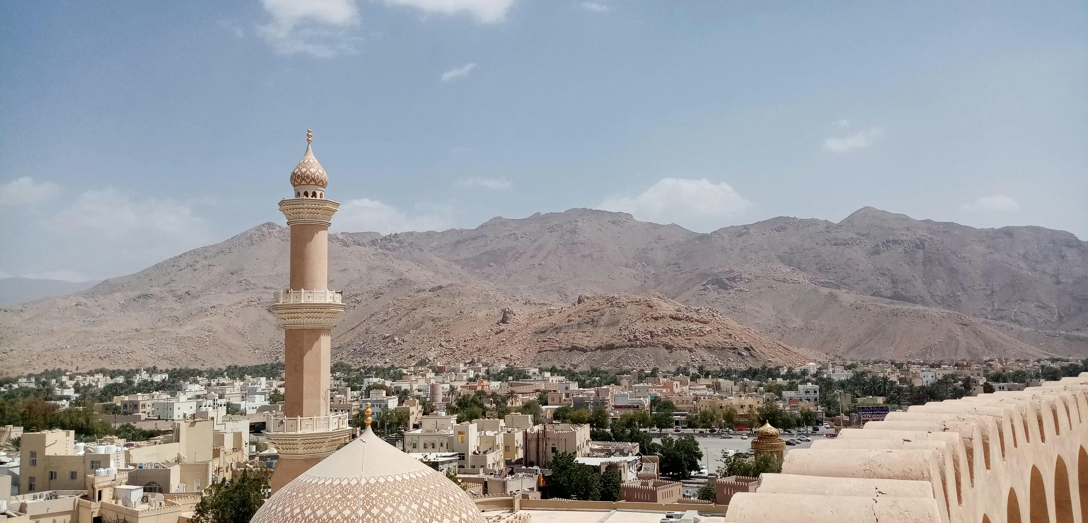 top view from the nizwa fort in oman with mountains and a mosque upfront