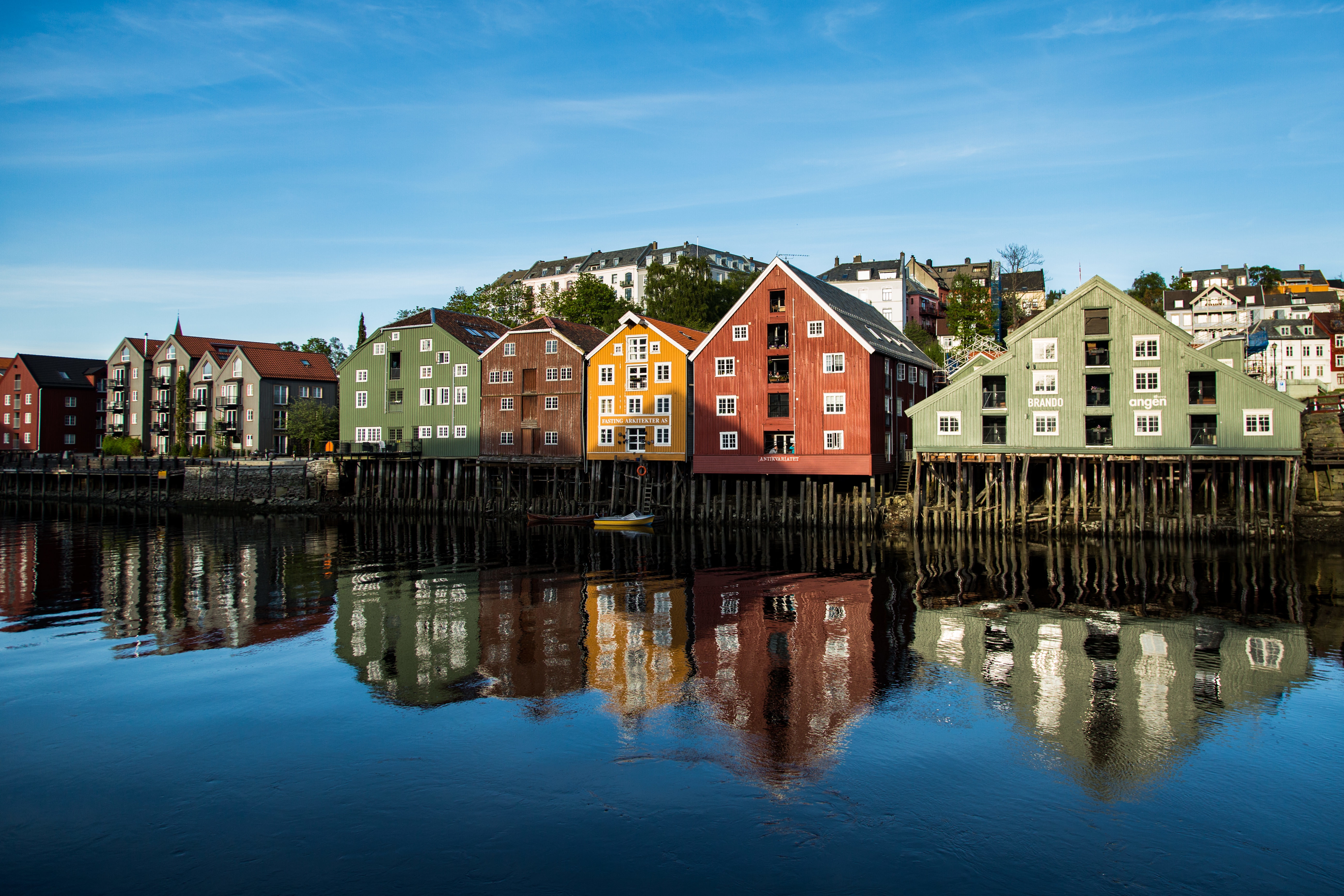 range buildings shore reflecting lake clear blue sky
